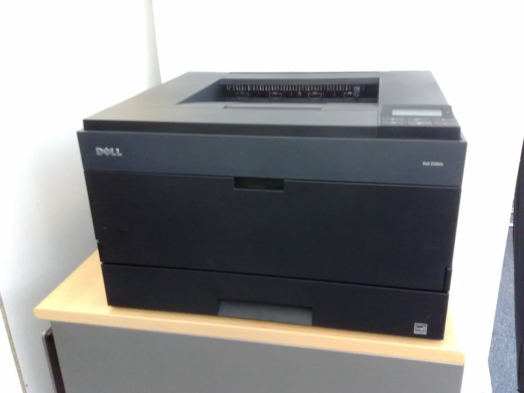 Black Dell laser printer on an office table